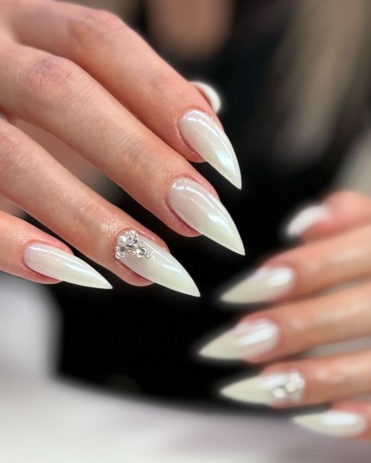 Milchig-weisse Stiletto-Nägel mit Perlen und Strass