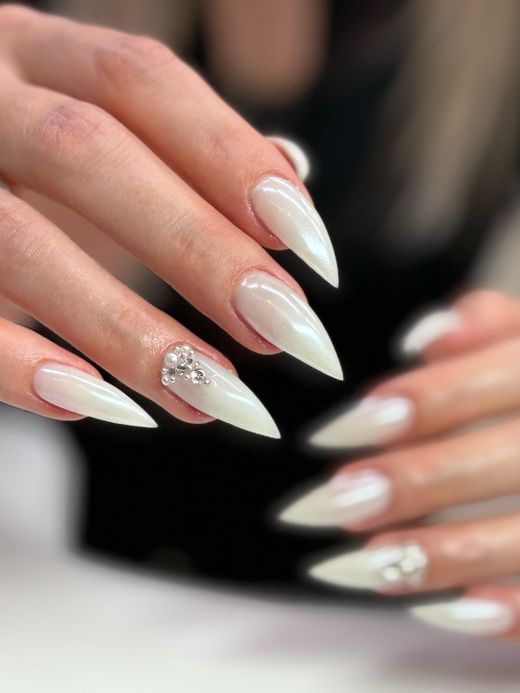 Milky white stiletto nails with pearls and rhinestones