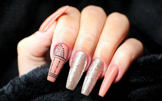 Nude ballerina nails with gold glitter and ornament
